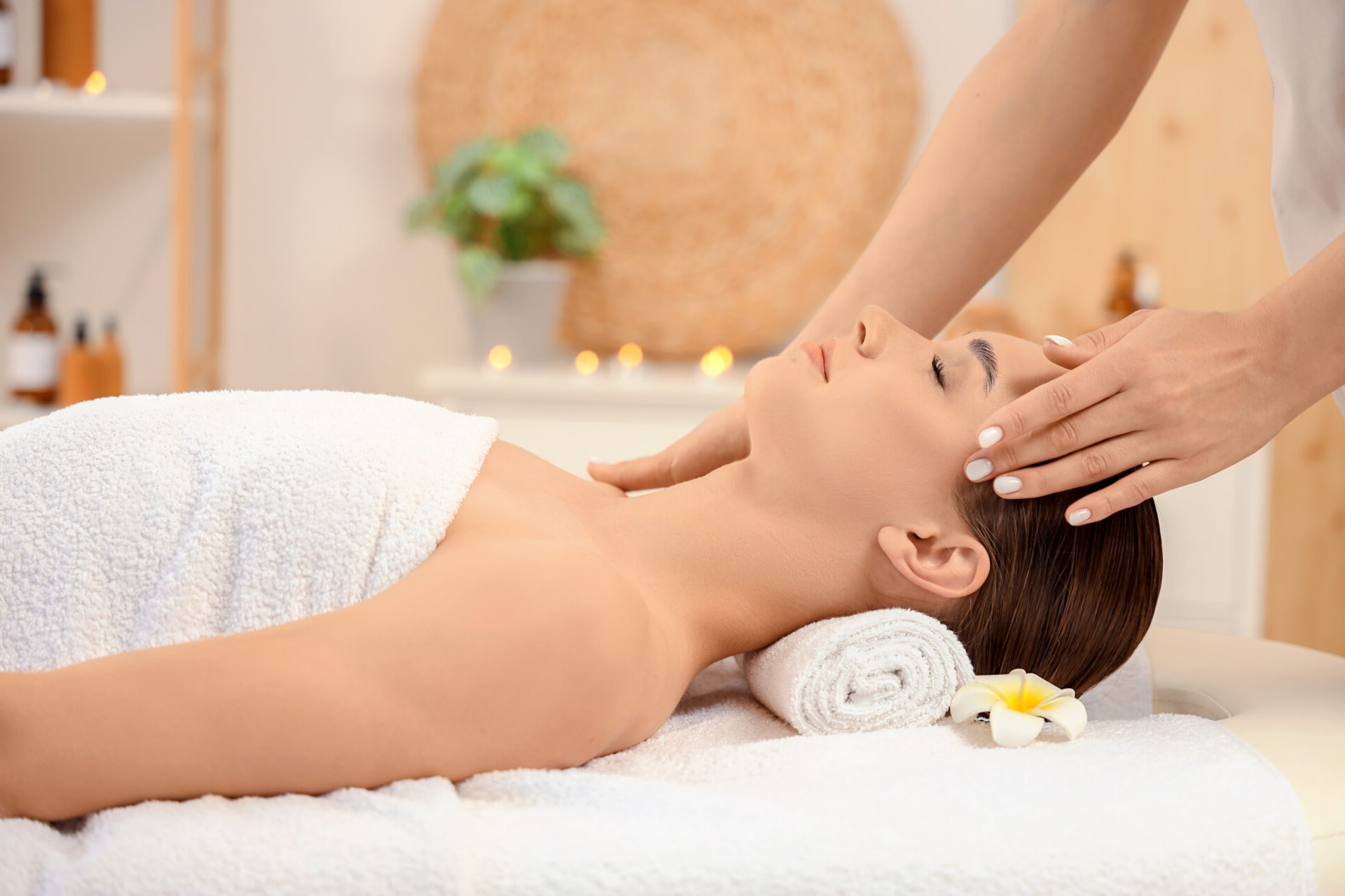 Beautiful young woman receiving facial massage in spa salon
